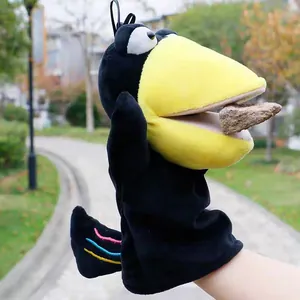 Detailed view of plush crow hand puppet with movable mouth holding a small prop