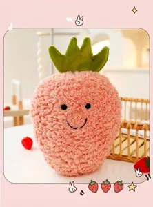 Primo piano di peluche a forma di frutto rosa con trama riccia e viso sorridente