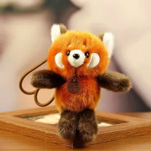 Detailed close-up view of a soft orange and brown plush red panda pendant keychain.