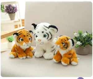 A family set of realistic tiger plush toys in white and orange colors on a cozy sofa