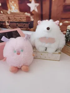 Close-up detail of soft pink and white fluffy monster plush toys in a cozy room