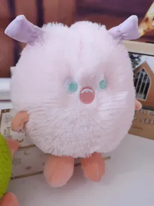 Cute soft pink furry monster plush toy featuring purple horns and green eyes detail