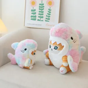 Two cute rainbow shark cat plush toys in different sizes shown on a cozy beige sofa background