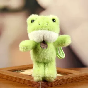 Detailed close-up view of the soft light green plush frog keychain with a wooden tag