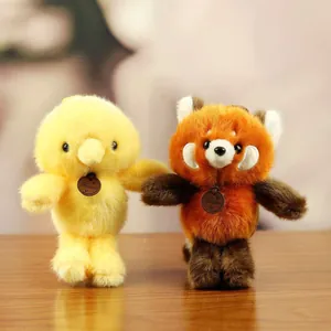 Pair of cute plush animal keychains, yellow bird and red panda, on a wooden table.