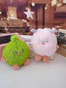 Close-up detail view of fluffy monster plush toys in lime green and soft pink colors