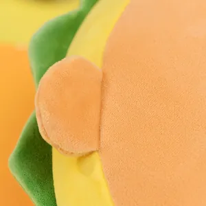 Primer plano de un cojín de peluche de hamburguesa con tela naranja y verde vibrante