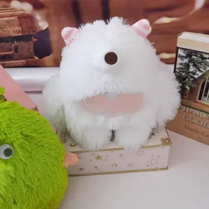 Detailed close-up of a white fluffy monster plush toy sitting on a decorative gift box