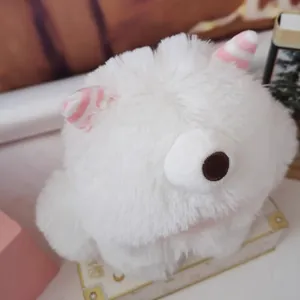 Close-up of white long-haired monster plush toy with soft texture and pink striped ears.