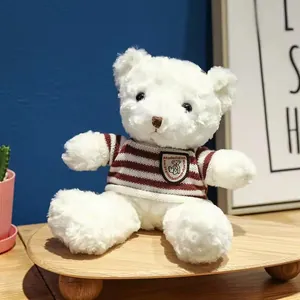 White plush teddy bear wearing a red and white striped sweater on a wooden stand