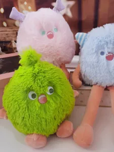 Detail view of colorful fuzzy monster plush toys featuring expressive embroidered faces