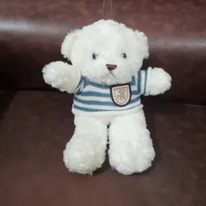 Soft white plush teddy bear wearing a cozy blue and white striped knitted sweater detail