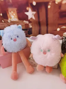 Close-up of two adorable long-haired monster plush dolls in light blue and soft pink