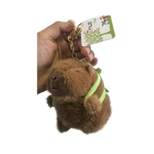 Adorable porte-clés capybara en peluche marron avec un petit sac à dos vert mignon