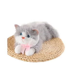 Cute lifelike grey and white plush ragdoll cat toy with pink bow on circular straw mat