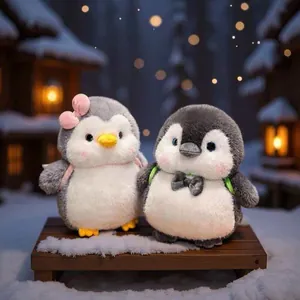 Cute couple penguin plush toys with mini backpacks in snowy winter scene