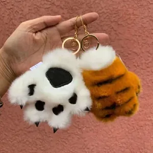 Close-up of soft plush tiger paw keychain with fluffy texture and metal ring