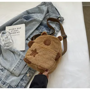 Primer plano de un lindo bolso bandolera de peluche Capibara marrón sobre una chaqueta