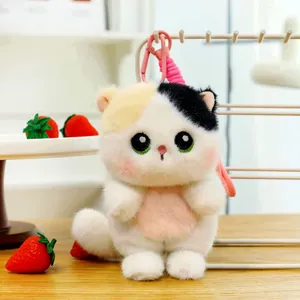 Macro view of a cute tri-color kitten plush keychain charm with soft fur and green eyes
