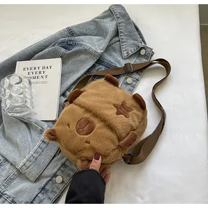 Primer plano de un bolso bandolera de Capibara de felpa marrón con textura suave.