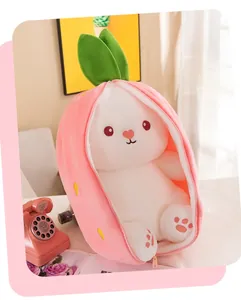 Plush rabbit toy tucked inside a pink strawberry-themed zippered case on a white table.
