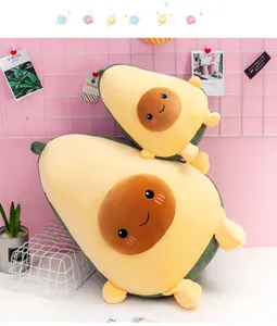 Simpatici peluche a forma di avocado in due dimensioni su sfondo rosa decorativo.