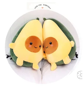 Dettaglio di due morbidi cuscini di peluche a forma di avocado con facce sorridenti