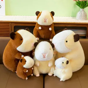 Soft guinea pig plush toys in various sizes and colors on a brown leather sofa