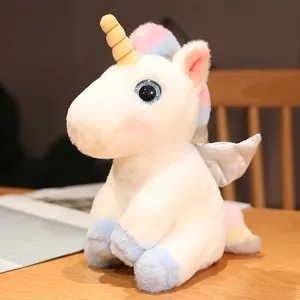 Nahaufnahme weißes Einhorn-Plüschtier mit goldenem Horn und bunten Flügeln
