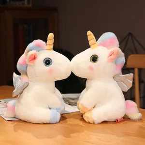 Detailansicht von zwei weißen Einhorn-Plüschtieren mit Regenbogenmähnen und Flügeln