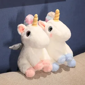 Detailansicht von zwei weißen Einhorn-Plüschtieren mit goldenen Hörnern und Regenbogenmähnen