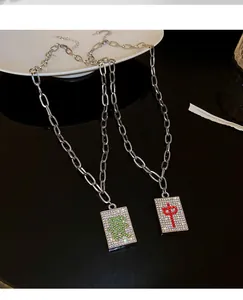 Detailed view of mahjong tile pendants with rhinestone 'Zhong' and 'Fa' designs