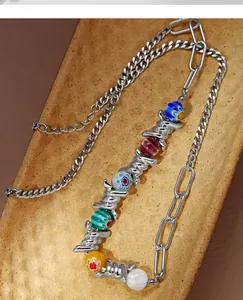 Close-up of punk-style necklace featuring colorful glass beads and silver barbed wire links.