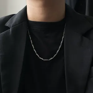 Close-up view of a minimalist silver bamboo-joint stainless steel necklace on model