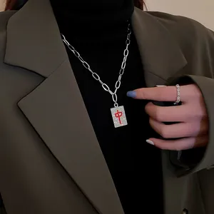 Close-up of Mahjong 'Zhong' pendant necklace with red rhinestones on a silver chain.
