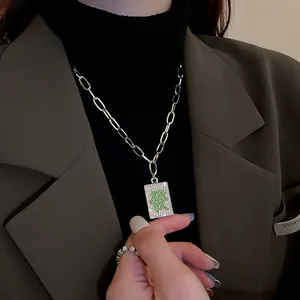 Close-up of silver Mahjong Zhong character pendant necklace with green rhinestones