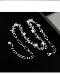 Detailed view of silver barbed wire necklace featuring opal-like moonstone inlays