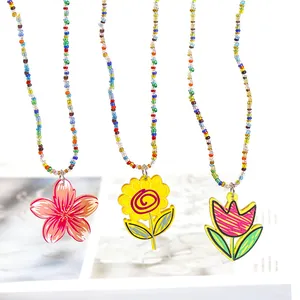 Detailansicht bunter Perlenketten mit Acryl-Blumenanhängern (Kirschblüte, Sonnenblume, Tulpe)