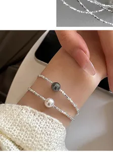 Dettaglio ravvicinato della collana in argento con eleganti perle bianche e grigie