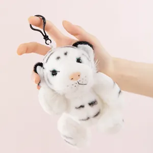 Dettaglio di un portachiavi in peluche di tigre bianca morbida tenuto in mano