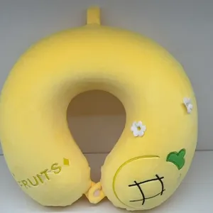 Détail de l'oreiller de voyage jaune en forme de U avec broderie de fruits et peluche