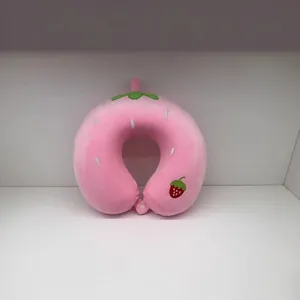 Gros plan d'un oreiller de voyage en forme de fraise rose avec une texture douce