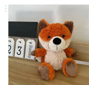 Detailed close-up of a soft orange plush fox toy sitting on a rustic wooden surface.