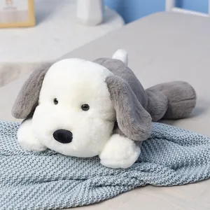 Adorable plush puppy dog in prone pose, soft grey and white fluffy sleeping pillow