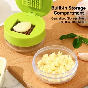 Manual garlic press mincer with transparent storage container and green lid