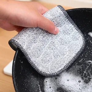 Premium double-layered silver wire dishcloth being used to effectively clean a black cooking pot