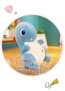 Primer plano de un lindo peluche de dinosaurio azul sentado en una cesta de alambre