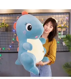 Primer plano de un peluche de dinosaurio azul sostenido por una modelo para referencia