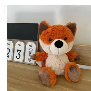 Adorable orange and cream forest fox plush toy sitting on a wooden desk as a cute gift
