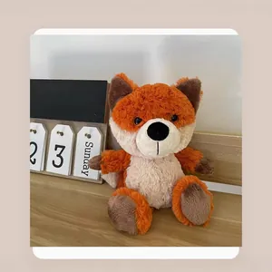 Cute orange forest fox plush toy doll sitting on a wooden desk as a home decor gift
